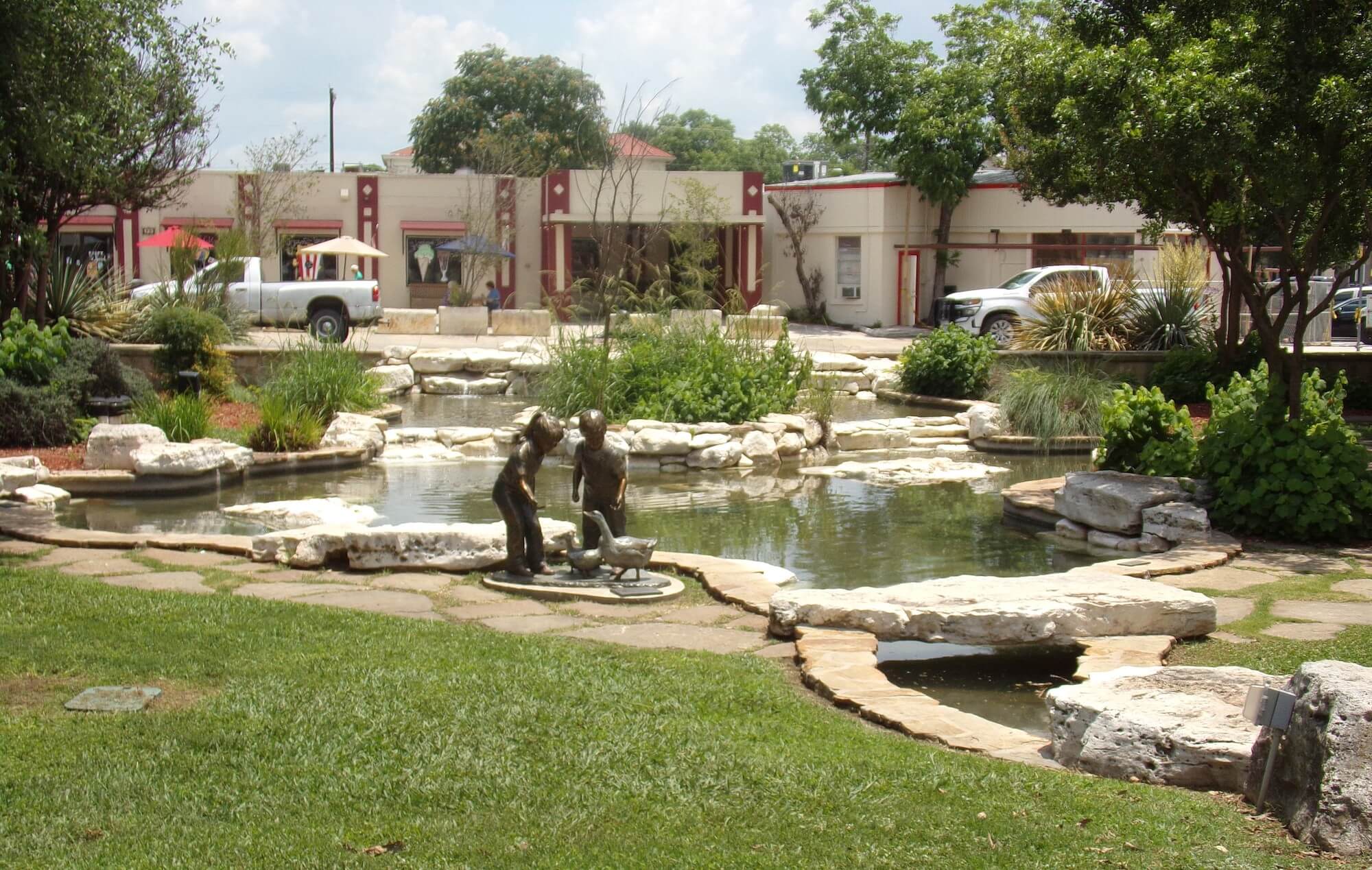 Lovely pond with statue of a boy and girl playing with ducks in Boerne, Texas.