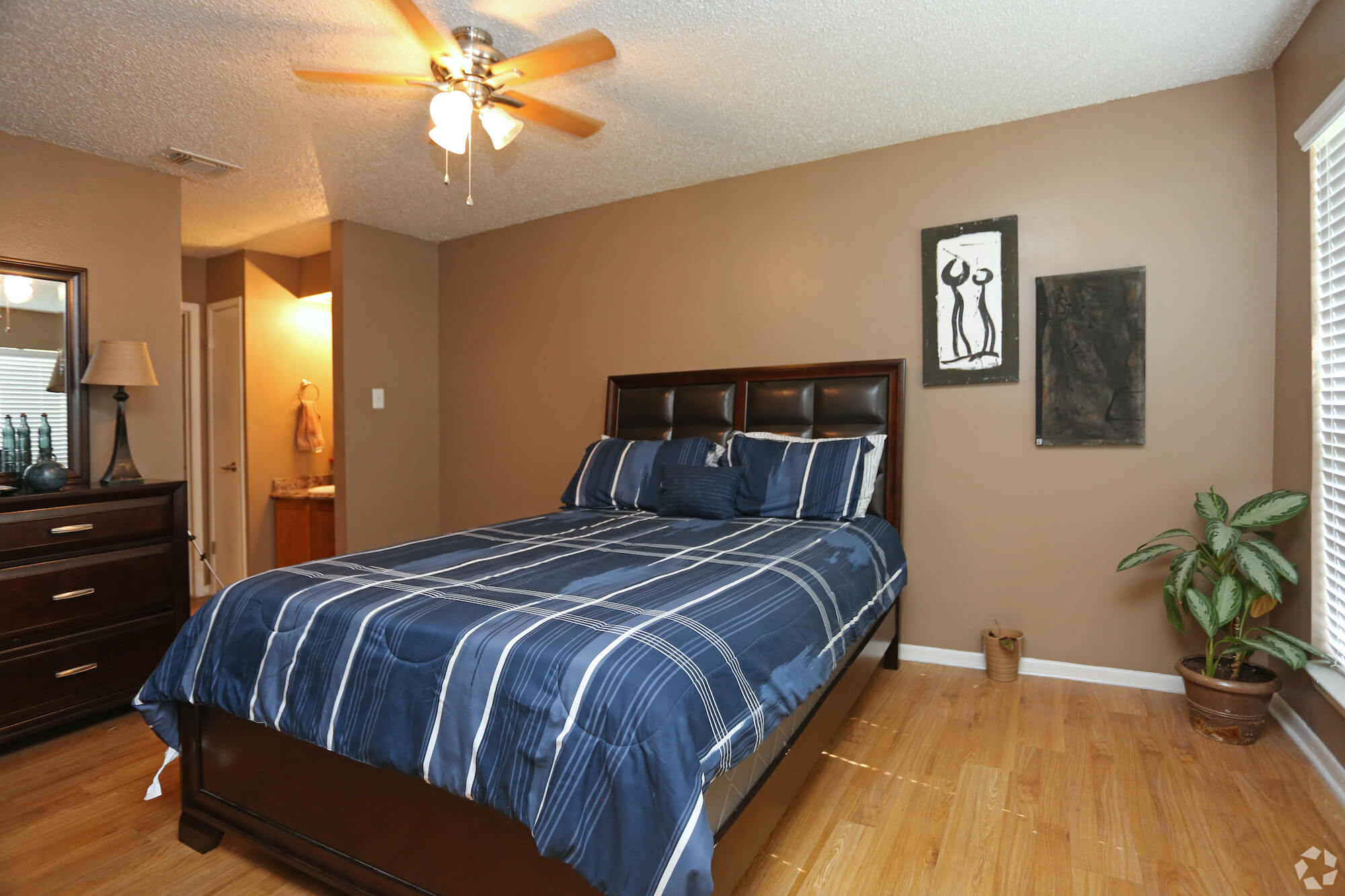 Arbors of Boerne Apartments bedroom with fan and bathroom.